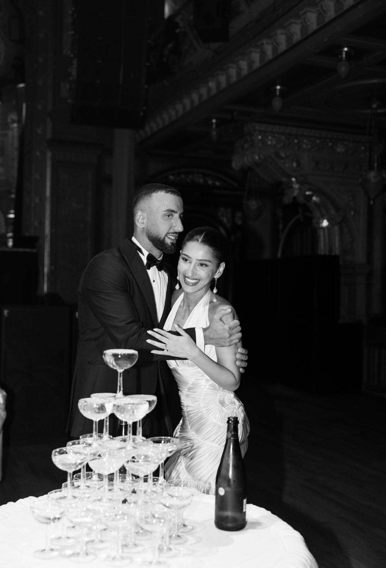 Bride in a draped gown beside the champagne tower at the wedding at Berns Salonger